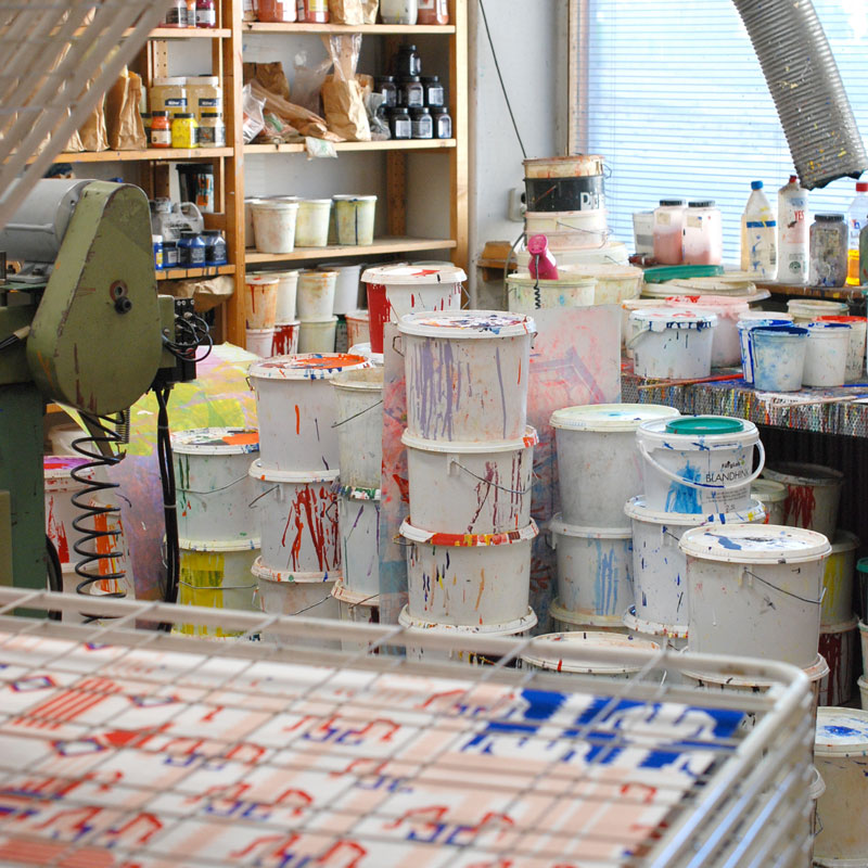 Drying rack for newly printed sheets of paper and a view of the workshops color stock.